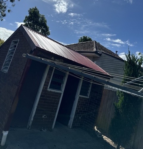 Roof restoration in progress, new colorbond section against original tile roof