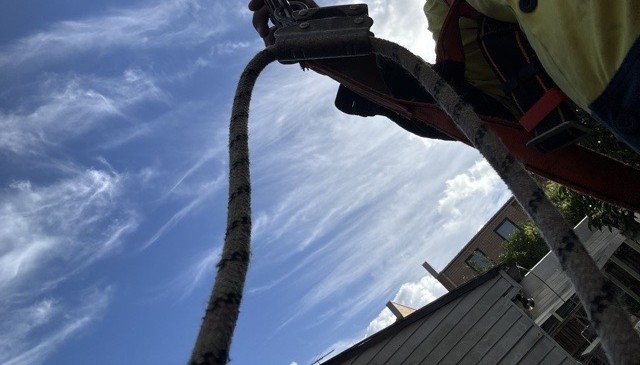 Crew member harnessed for a scheduled roof inspection